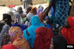 Women sit under a tree waiting for Hajia Hawa to give them free food. Many of them have malnourished children, Maiduguri, Nigeria, Sept. 2016. (Photo: C. Oduah)