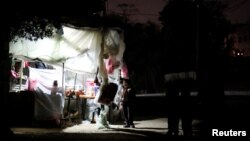 Un jeune palestinien debout devant une boutique de fortune éclairée à l’aide d’une batterie pendant une coupure d’électricité à Beit Lahiya dans le nord de la bande de Gaza, 11 janvier 2017.