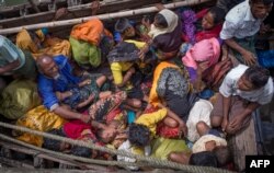 FILE - This photograph taken Sept.12, 2017, shows Rohingya refugees arriving by boat at Shah Parir Dwip on the Bangladesh side of the Naf River after fleeing violence in Myanmar.