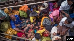 FILE - This photograph taken on Sept.12, 2017 shows Rohingya refugees arriving by boat at Shah Parir Dwip on the Bangladesh side of the Naf River after fleeing violence in Myanmar.