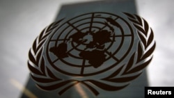 FILE - The United Nations headquarters building is pictured though a window with the U.N. logo in the foreground in New York, Aug. 15, 2014. 