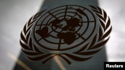 FILE - The United Nations headquarters building is pictured though a window with the UN logo in the foreground in New York, Aug. 15, 2014. 