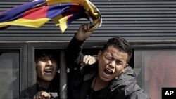 Tibetan exiles shout slogans from police vehicle after being detained outside Chinese Embassy in New Delhi, India, Feb. 16, 2012.