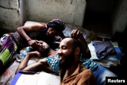 Rodrigo (right), 26, Wam (center), 24, and Teflon, 19, members of the lesbian, gay, bisexual and transgender (LGBT) community who have been invited to live in a building, relax in downtown Sao Paulo, Brazil, Nov. 8, 2016.