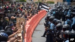 Demonstrators holding wooden shields are confronted by police during a protest against the Federal Fiscal Control Board, as part of the May Day celebration, in San Juan, Puerto Rico, May 1, 2019.