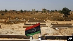 A rebel flag is installed at the tomb of a fighter killed during fighting with forces loyal to Moammar Gadhafi in rebel-held Benghazi, Libya, July 17, 2011