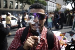A supporter of the legalization of marijuana smokes outside the Supreme Court in Mexico City, Nov. 4, 2015.
