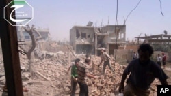 In this May 18, 2013 citizen journalism image provided by Qusair Lens shows Syrians inspecting the rubble of damaged buildings due to government airstrikes, in Qusair, Homs province.