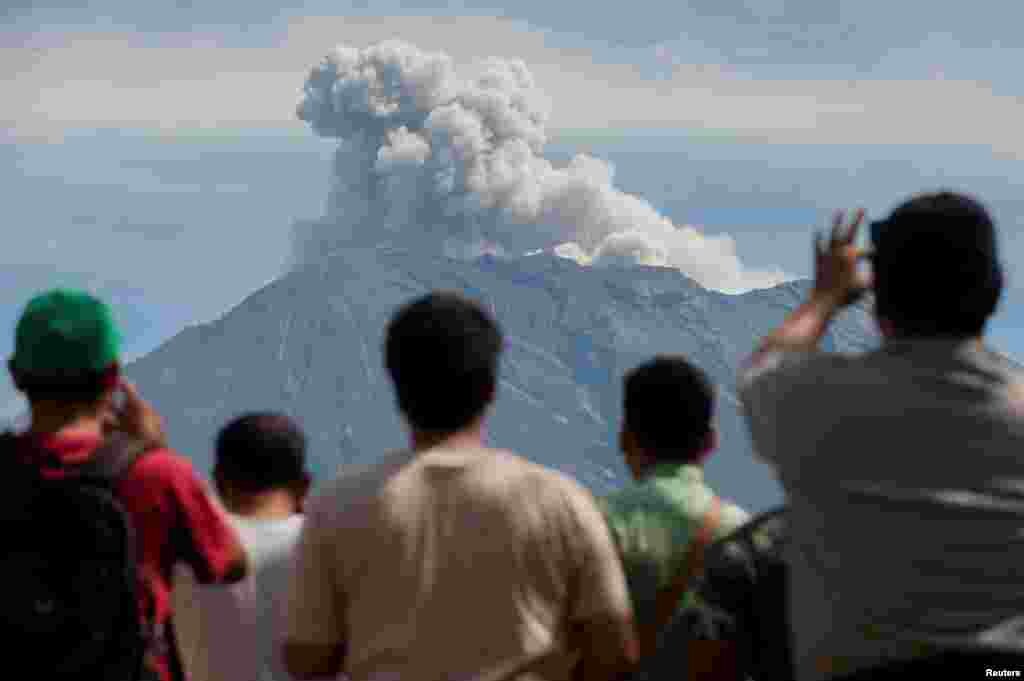 مردم در حال تماشای دود و خاکستر کوه آتشفشان در بالی اندونزی