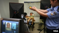 中國江蘇省南京市一名7個月大的幼童正在派出所裡拍攝他的居民身份證照片。 （2006年10月12日）