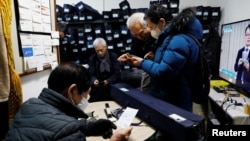 Park Gyung-sun checks the details of his job before leaving to deliver a parcel with the free subway service providing for elderly people, in Seoul, South Korea, Feb. 8, 2023.