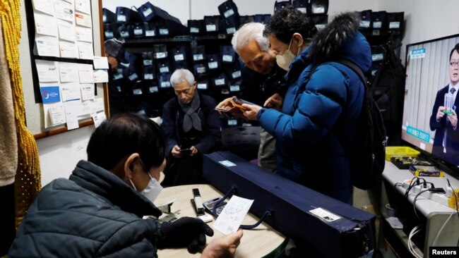 Park Gyung-sun checks the details of his job before leaving to deliver a parcel with the free subway service providing for elderly people, in Seoul, South Korea, Feb. 8, 2023.