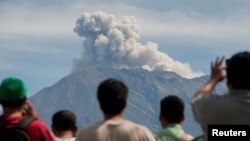 Warga mengamati Gunung Agung mengepulkan asap dan abu vulkanik dari pos pengamatan di Rendang, Kabupaten Karangasem, Bali (foto: dok). 