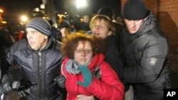 Belarus plainclothes policemen detain protesters during an opposition action devoted to the anniversary of the presidential election in Belarus, Minsk, Dec. 19, 2011.