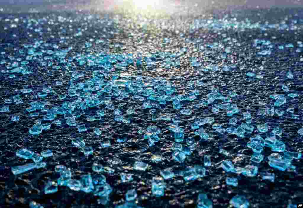 Broken glass from the window of a car in which a man was shot lies on the street in front of a kiosk in Hanau, Germany, two days after a 43-year-old German man shot and killed several people in a Frankfurt suburb on Feb. 19, 2020.