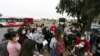 Migrantes escuchan a un voluntario en un estacionamiento después de ser detenidos y procesados ​​para solicitar asilo por parte de Estados Unidos. autoridades, viernes 12 de abril de 2024, en San Diego. (Foto AP/Gregory Bull)