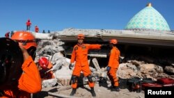 Tim Basarnas berusaha mencari korban di antara reruntuhan bangunan sebuah masjid di Pemenang, Lombok, hari Rabu (8/8).