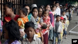 Cambodian villagers for countryside line up as wait for a medical check-up outside the children hospital of Kuntha Bopha, in Phnom Penh, Cambodia, Wednesday, July 11, 2012. A deadly form of a common childhood illness has been linked to many of the mysterious child deaths in Cambodia that caused alarm after a cause could not immediately be determined, officials said. (AP Photo/Heng Sinith)