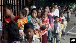 Cambodian villagers from the countryside line up as they wait for a medical check-up outside the children hospital of Kuntha Bopha, in Phnom Penh, Cambodia, Wednesday, July 11, 2012.