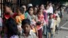 Cambodian villagers for countryside line up as wait for a medical check-up outside the children hospital of Kuntha Bopha, in Phnom Penh, Cambodia, Wednesday, July 11, 2012. A deadly form of a common childhood illness has been linked to many of the mysterious child deaths in Cambodia that caused alarm after a cause could not immediately be determined, officials said. (AP Photo/Heng Sinith)