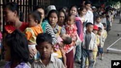 Cambodian villagers for countryside line up as wait for a medical check-up outside the children hospital of Kuntha Bopha, in Phnom Penh, Cambodia, Wednesday, July 11, 2012. A deadly form of a common childhood illness has been linked to many of the mysteri