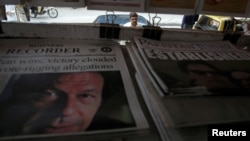 FILE -A man looks at newspapers at a stall a day after general election in Islamabad, Pakistan, July 26, 2018. 