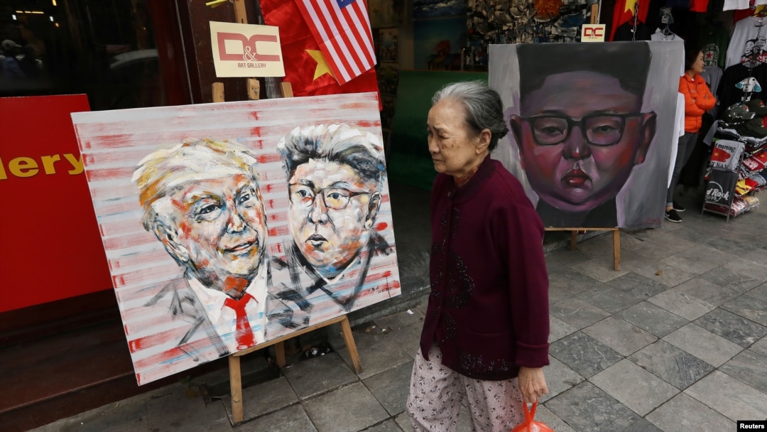 Seorang perempuan berjalan melintas di depan lukisan gambar Pemimpin Korea Utara Kim Jong Un dan Presiden AS Donald Trump menjelang KTT AS-Korut kedua di Hanoi, Vietnam, 27 Februari 2019.
