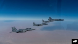 지난 26일 미국 루이지애나주 박스데일 공군기지에서 출격한 B-52 스트래토포트리스 폭격기(오른쪽)가 사우디 아라비아 공군 F-15A 전투기들의 호위를 받으며 페르시아만 영공에서 비행하고 있다. 