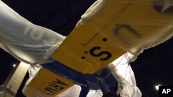 FILE - One of the few surviving planes that were used to train the Tuskegee Airmen is readied for display at the Smithsonian National Museum of African American History and Culture in Washington, July 18, 2016. 