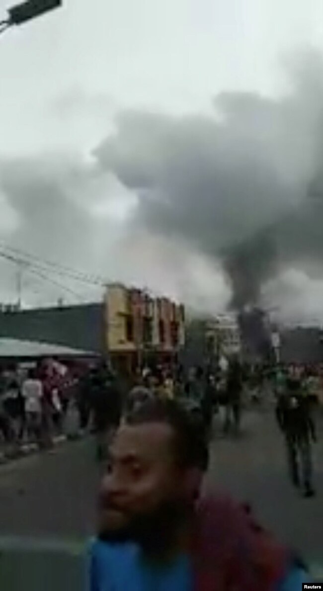 Asap membubung dari gedung DPRD dan ban-ban yang dibakar massa saat unjuk rasa di Manokwari, Provinsi Papua, Senin, 19 Agustus 2019. (Foto: media sosial/Efan KMur via Reuters)