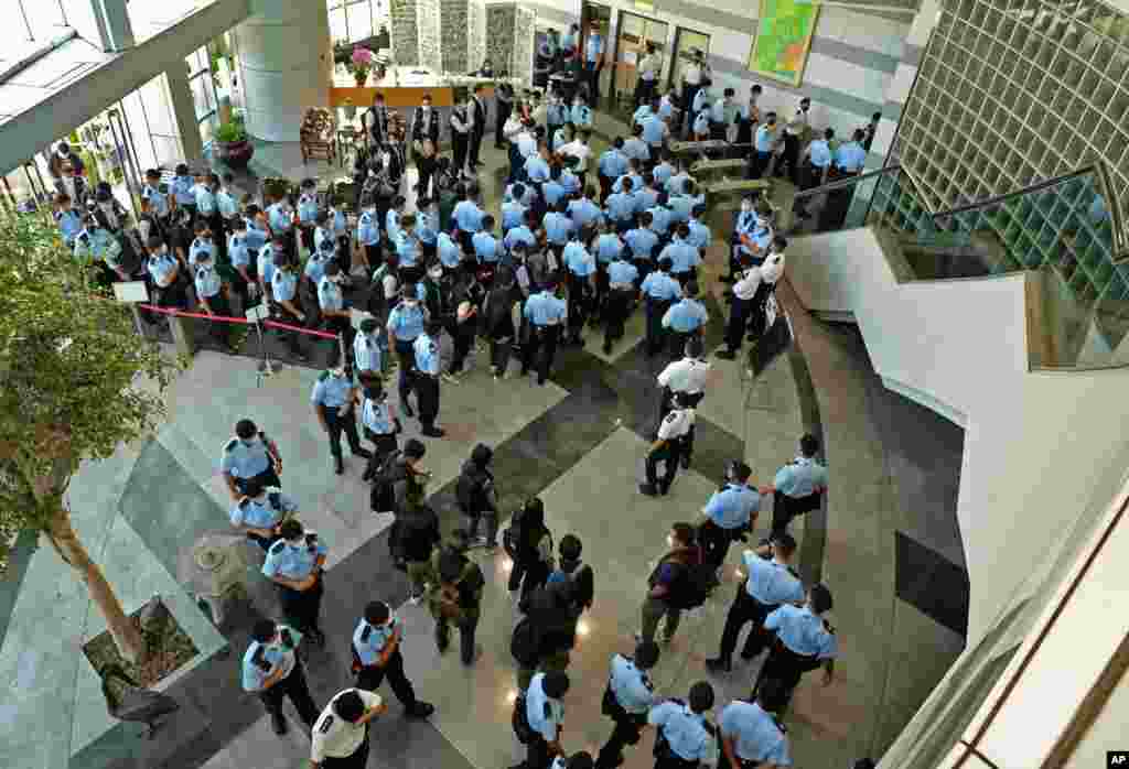 Police officers gather at the lobby of headquarters of Apple Daily in Hong Kong. Hong Kong police arrested the chief editor and four other senior executives of Apple Daily under the national security law on suspicion of collusion with a foreign country to endanger national security, according to local media reports.
