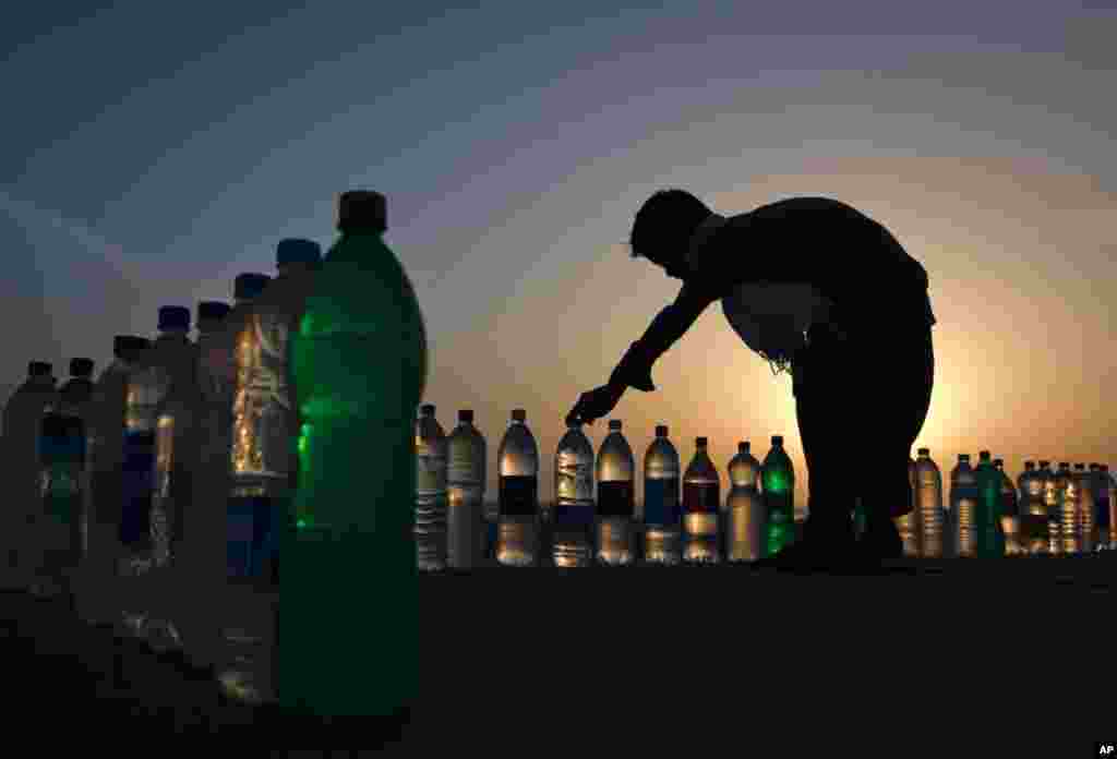 A boy arranging bottles of drinking water for sale at 10 PKR ($0.11) along Karachi's Clifton beach March 15, 2012. (Reuters)