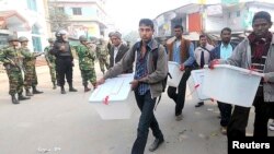 Members of the election commission remove election material after hearing news of a possible attack on polling booths by protesters in Bogra, Jan. 5, 2014. 