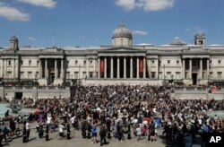 People, some of them kneeling gather in Trafalgar Square in central London on Sunday, May 31, 2020 to protest against the recent killing of George Floyd by police officers in Minneapolis that has led to protests across the US.