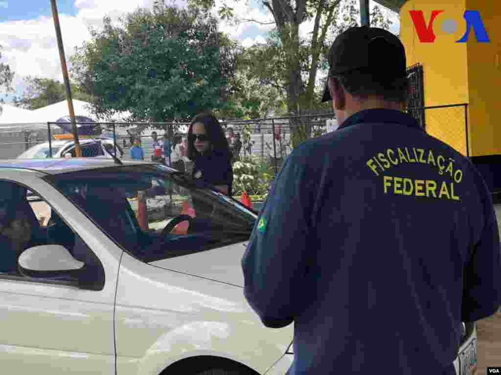 Policía loca realiza un revisión de rutina a un carro en el punto de control de la frontera en Pacaraima, Brasil. Foto: Celia Mendoza - VOA