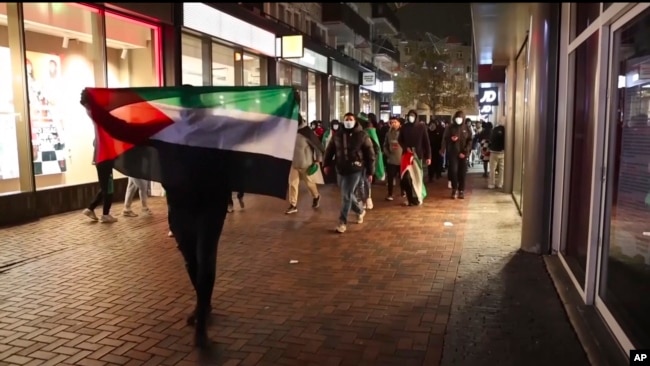 En esta imagen tomada de un video, simpatizantes pro palestinos marchan con banderas palestinas cerca del estadio Ajax en Ámsterdam, Países Bajos, el 7 de noviembre de 2024.