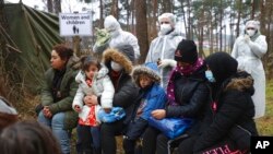 Para migran menunggu janji dengan dokter Belarusia di pos pemeriksaan "Kuznitsa" di perbatasan Belarus-Polandia dekat Grodno, Belarus, 24 November 2021. (Foto: AP)