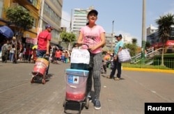 FILE - Days Laguado, a migrant from Venezuela, sells a traditional Venezuelan drink known as tizana at the Gamarra textile cluster in Lima's district of la Victoria, Peru, May 11, 2017.
