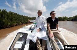 FILE - John Kerry, left, with Dartmouth College associate professor of history, use a map as they ride a boat on the river and identify the spot where the battle took place from which Kerry later received the Silver Star, Jan. 14, 2017.