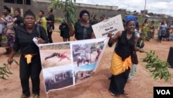 Women protest holding up a poster with images of atrocities committed in an ongoing conflict between government forces and armed separatists, in Bamenda, Cameroon, Sept. 7, 2018. (M.E. Kindzeka/VOA)