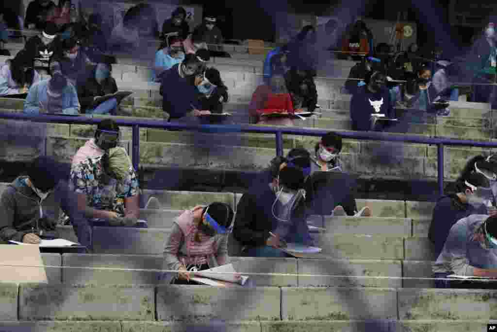 Students take an entrance exam for Mexico&#39;s National Autonomous University, amid the ongoing coronavirus pandemic at the University Olympic Stadium in Mexico City.