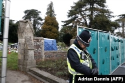 U.K. -- A policeman stands guard at temporary fencing at the London Road Cemetery where the wife and son of former Russian spy Sergei Skripal are buried, in Salisbur, March 14, 2018