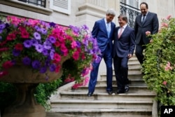 U.S. Secretary of State John Kerry, Qatari Foreign Minister Khaled al-Attiyah, right, and Turkish Foreign Minister Ahmet Davutoglu walk down a staircase at the Turkish ambassador's residence in Paris, 26 July, 2014.