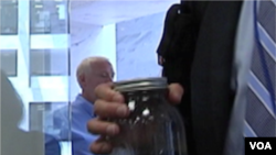 Un hombre trae una muestra del agua contaminada de la costa del golfo a una reunión con senadores en Washington.