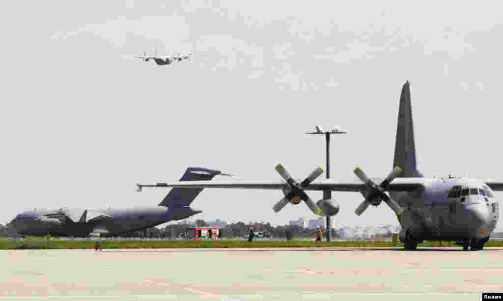 A Hercules transport aircraft of the Royal Dutch Airforce (right) and a Royal Australian Air Force Boeing C-17 are seen at an airstrip before transporting some of the remains of the victims of the downed Malaysia Airlines Flight MH17 airliner, at Kharkiv airport, Ukraine, July 25, 2014.