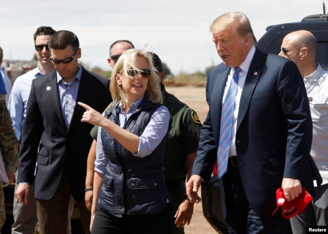 FILE - Homeland Security Secretary Kirstjen Nielsen, center, and commissioner for Customs and Border Patrol Kevin McAleenan, left, walk with U.S. President Donald Trump during a visit to a section of the border wall in Calexico California, April 5, 2019.