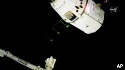 In this image taken from NASA Television, the SpaceX Dragon cargo spacecraft approaches the robotic arm for docking to the International Space Station, Saturday, Dec. 8, 2018. 