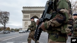 FILE - French soldiers cross the Champs Elysees avenue passing the Arc de Triomphe in Paris, Nov. 16, 2015. Prime Minister Manuel Valls says the government wants to prolong the current state of emergency set to expire May 26 to guarantee security for both the Euro 2016 football (soccer) championship and the Tour de France cycling race.