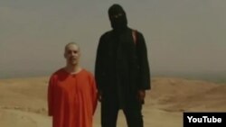 Un yihadista muestra a otro rehén supuestamente estadounidense, al que amenazan con decapitar si Estados Unidos no para su intervención en Irak y Siria.