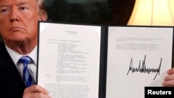 도널드 트럼프 미국 대통령이 지난 5월 백악관 외교접견실에서 이란핵합의(JCPOA) 탈퇴에 공식 서명한 후 이를 들어 보이고 있다. 